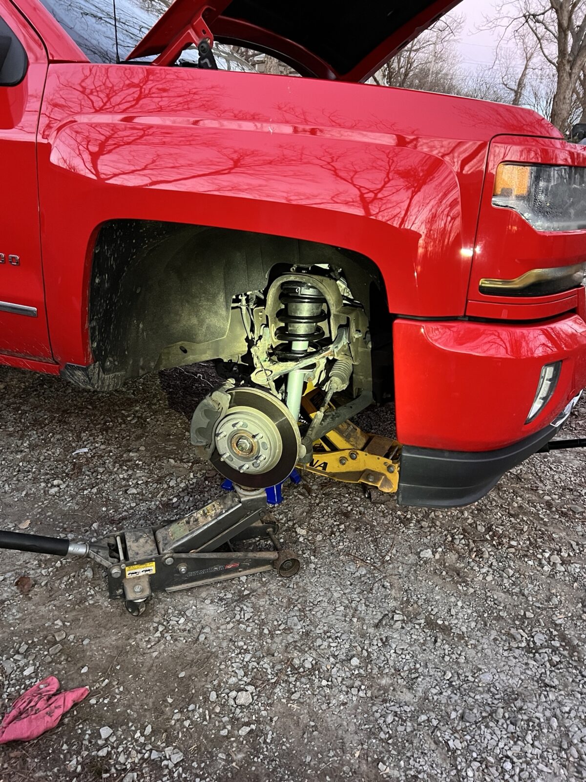 Suspension repair work being performed on a red truck