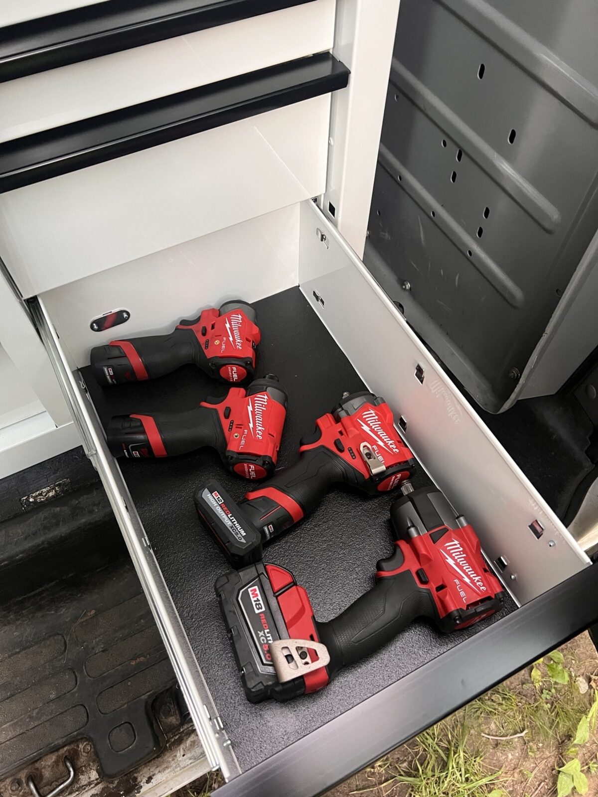 Organized Milwaukee cordless tools inside a service drawer